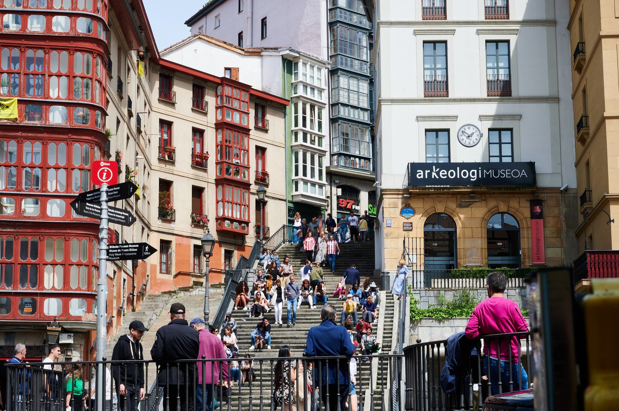 View of the Arkeologi Museoa and the stairs of the Calzadas de Mallona full of people in Bilbao, Spain.