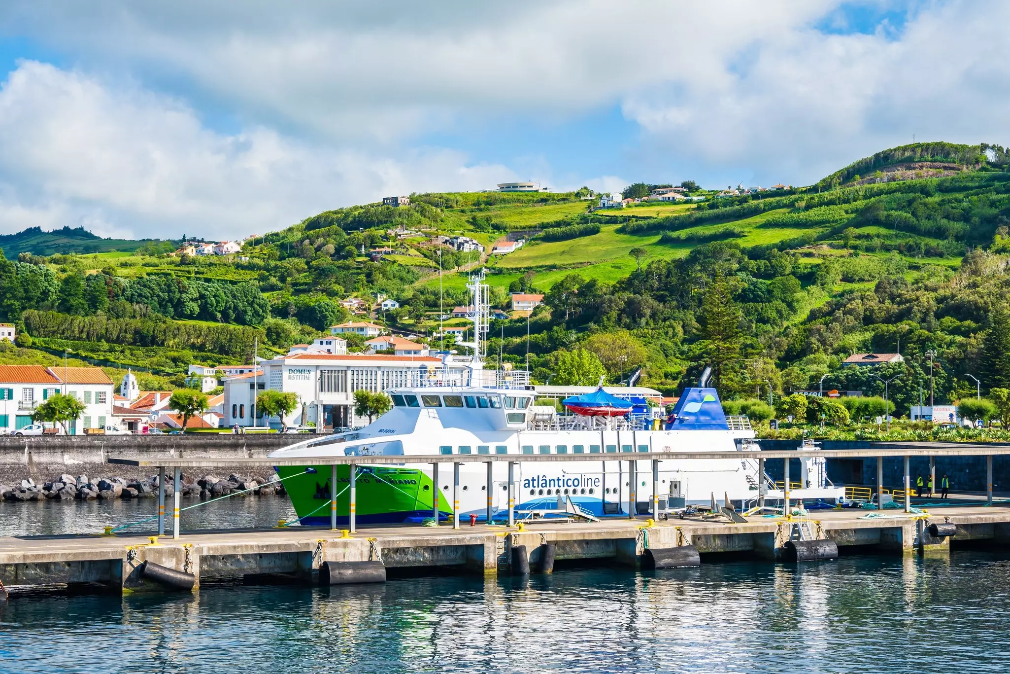 A ferry backed by green hills in the port of Horta on the island of Faial in the Azores.