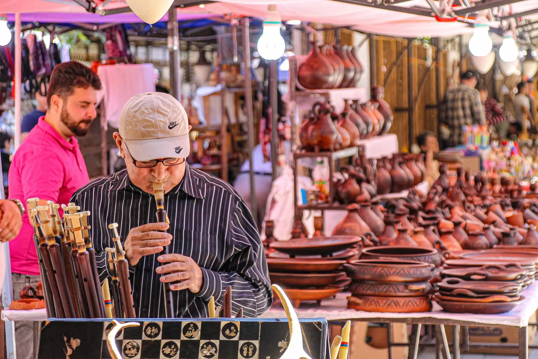 Yerevan, Armenia - July, 2024: The people of Armenia and the scene in the local markets. Local man checking out ancient craft, art and instruments.