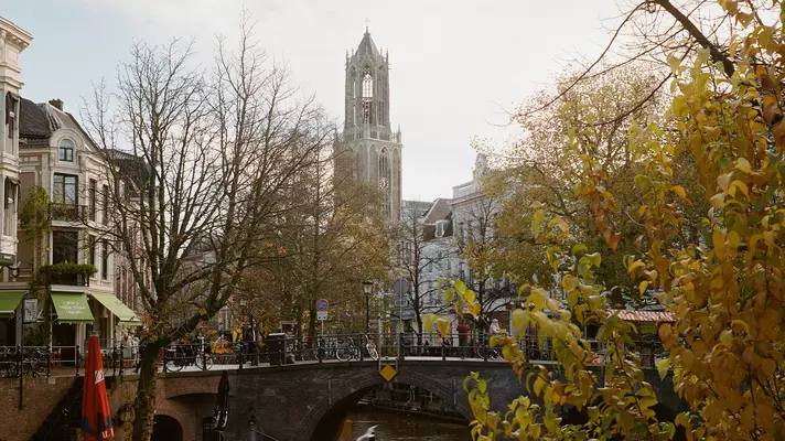 The spire of a building at the end of a quiet canal on a winter morning.
