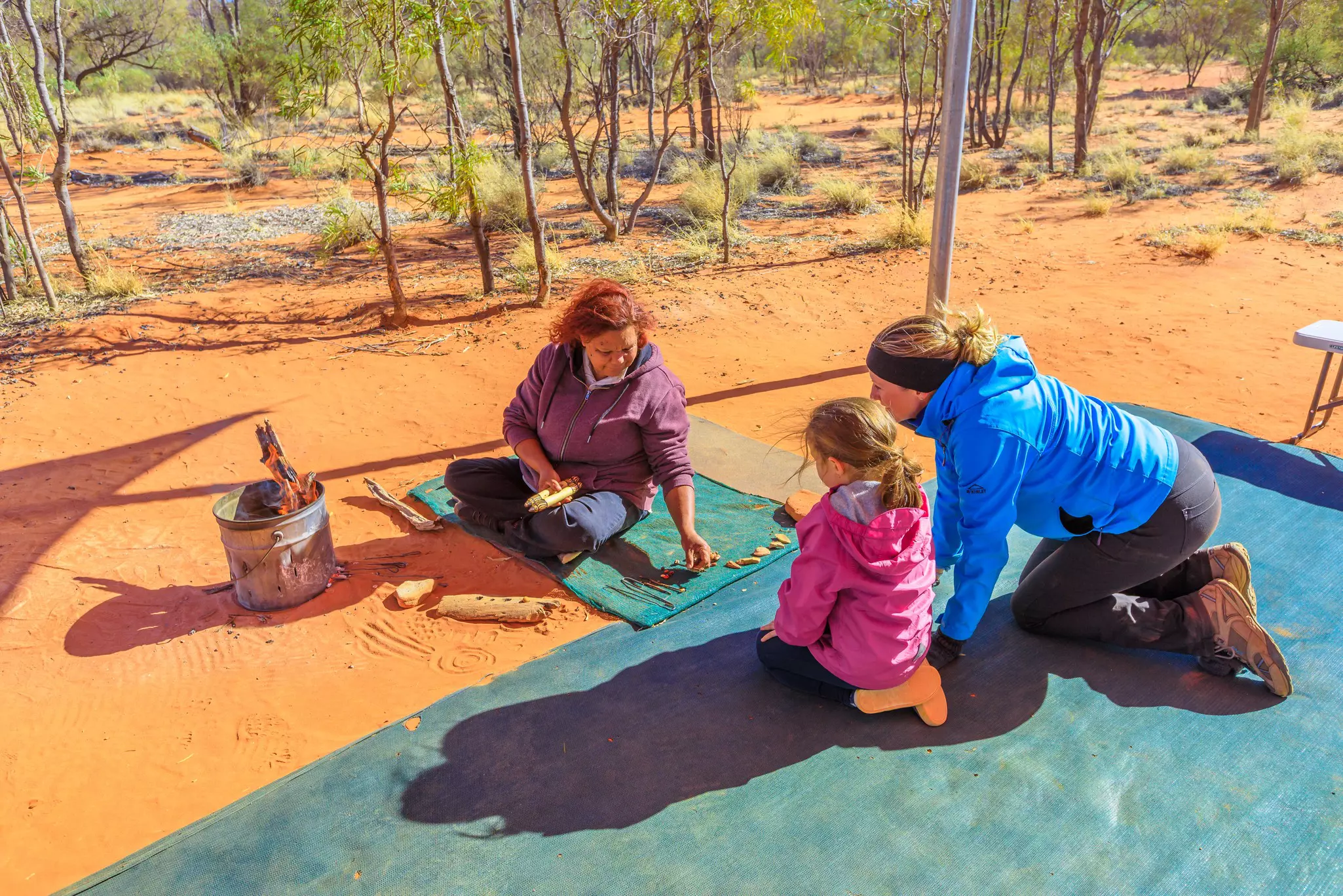 Kings Creek Station, Northern Territory, Australia - Aug 21, 2019: families with children observe variety colorful bush seeds gathered at Karrke Aboriginal Cultural Experience. Famous tour in outback.
