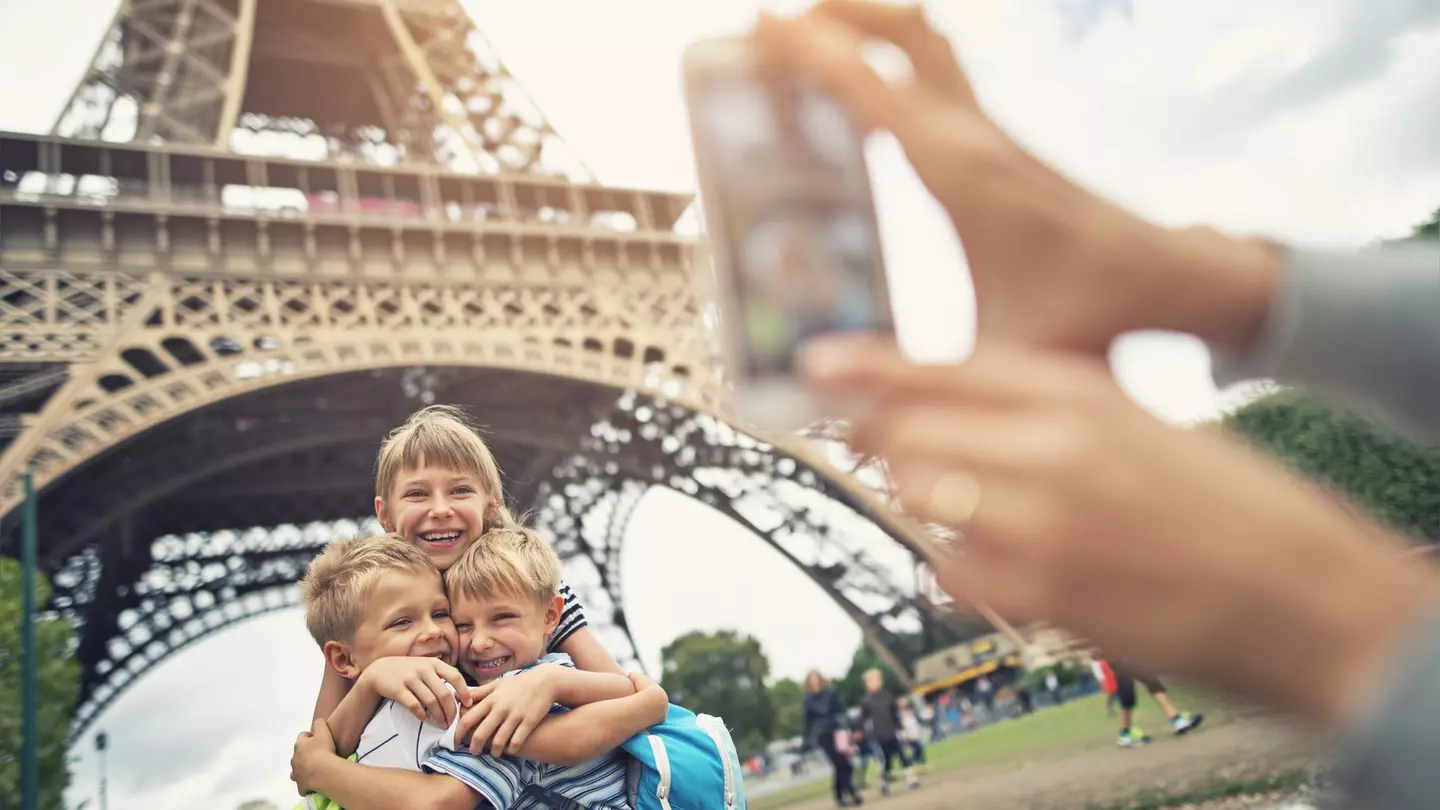 Kids tourists smiling at the camera near Eiffel Tower