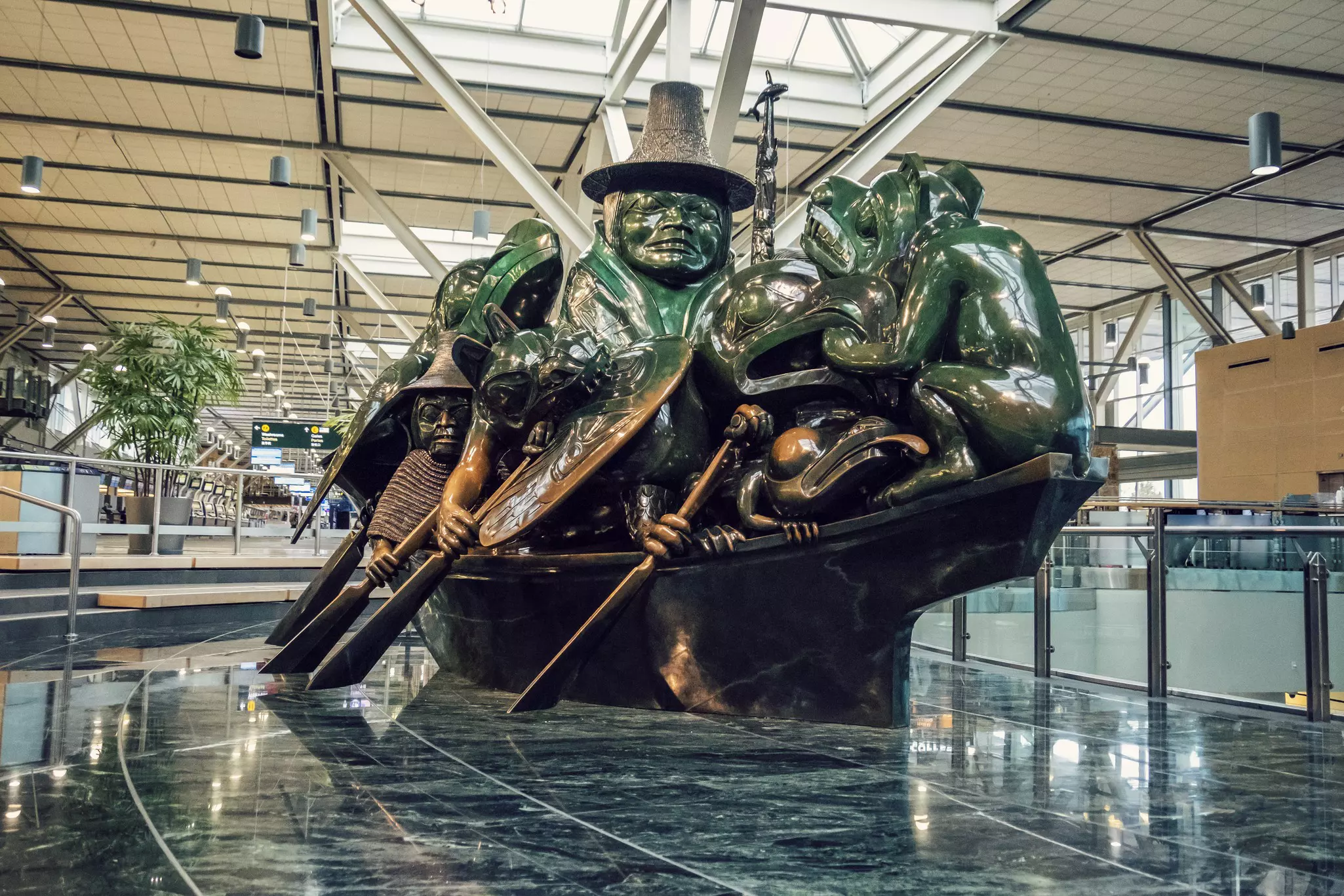 A large sculpture in the Vancouver airport depicts a group of people and spirit animals traveling in a canoe