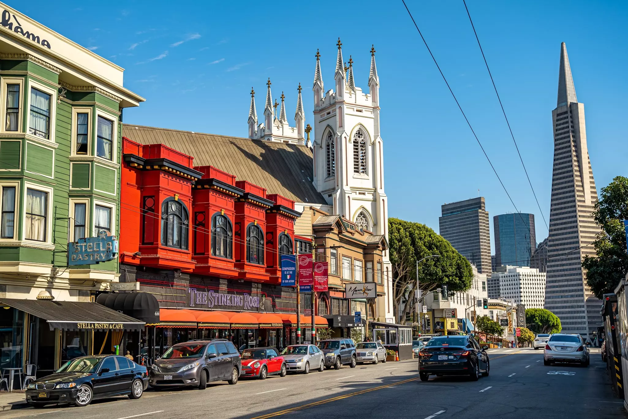 Street view of restaurants with city buildings in the distance, San Francisco, California.