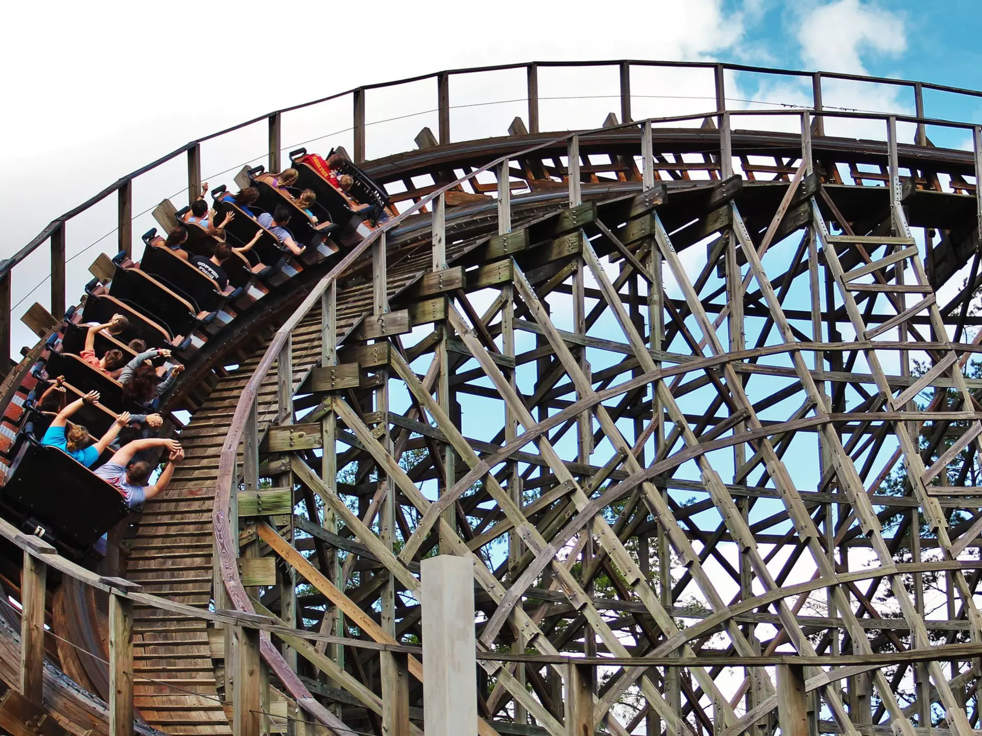 People with their hands up inside a looping wooden roller coaster in Dollywood