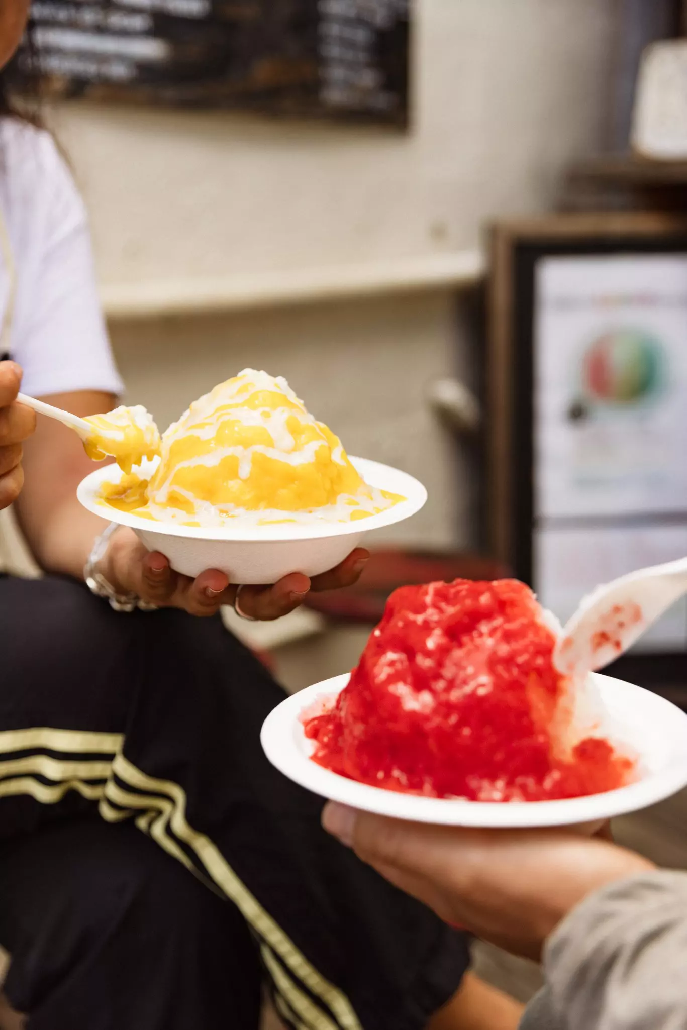 Two bowls with shave ice with colorful toppings.