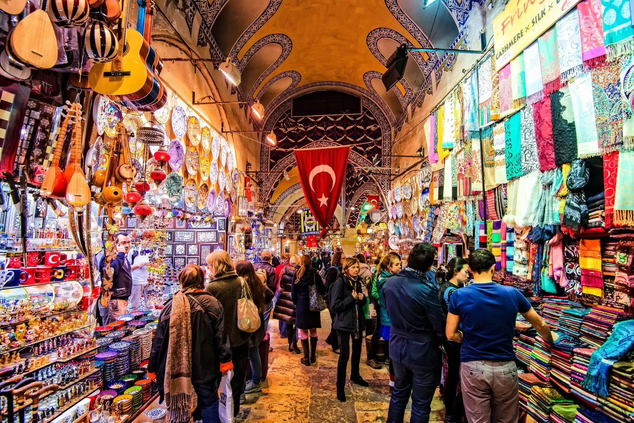 Shoppers at stalls in a covered bazaar.