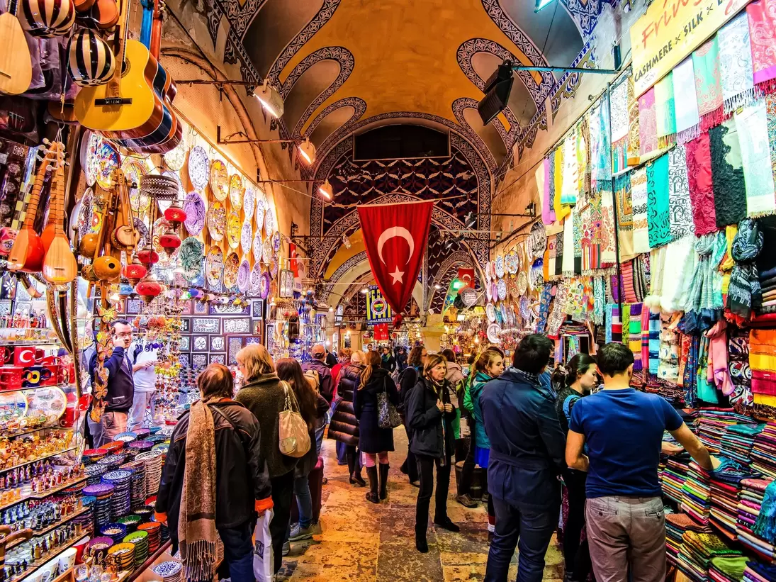 Shoppers at stalls in a covered bazaar.
