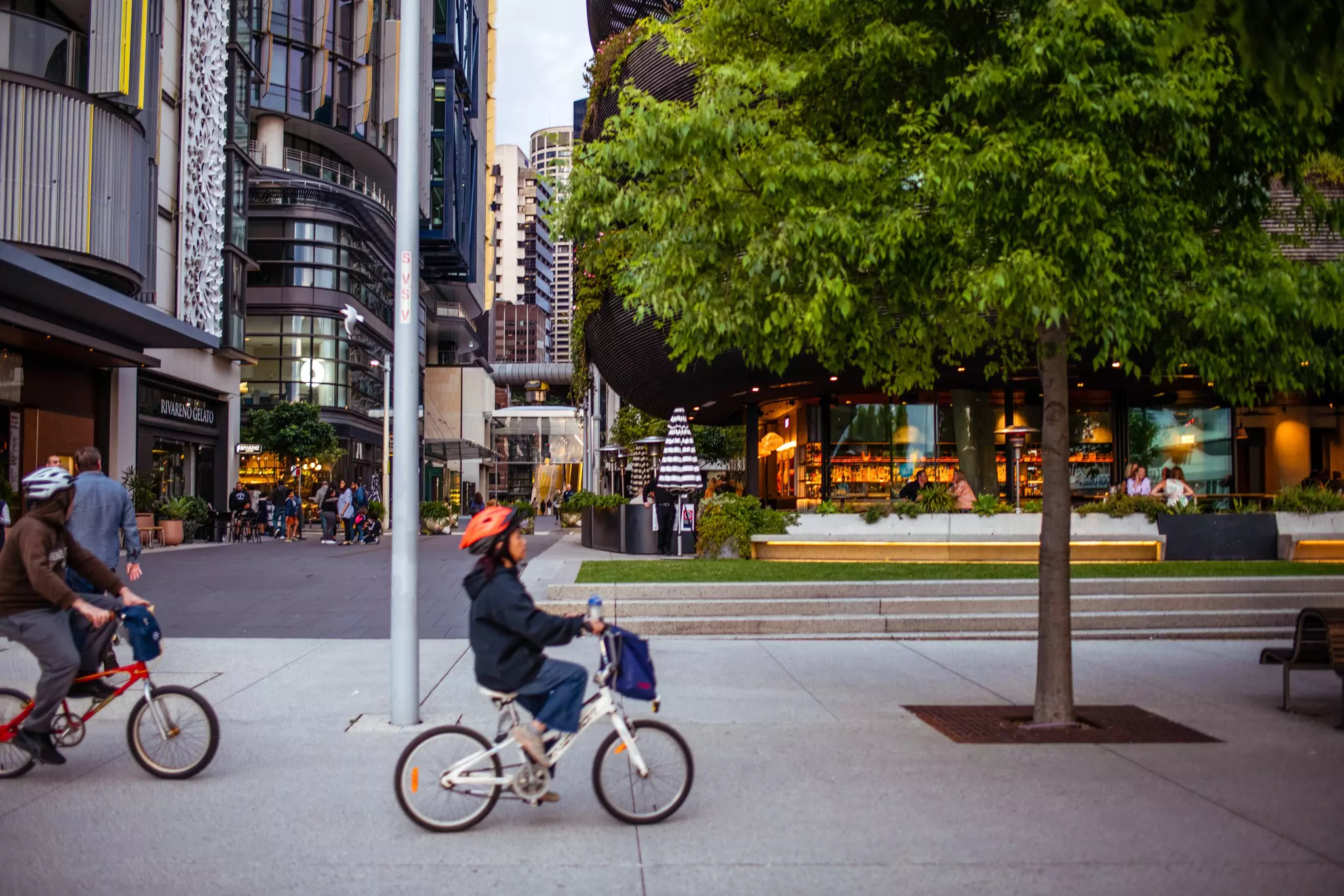 People ride bikes through an urban downtown.