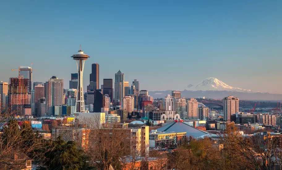 Seattle skyline with the Space Needle and downtown towers, snowcapped Mt Rainier on the horizon at sunset