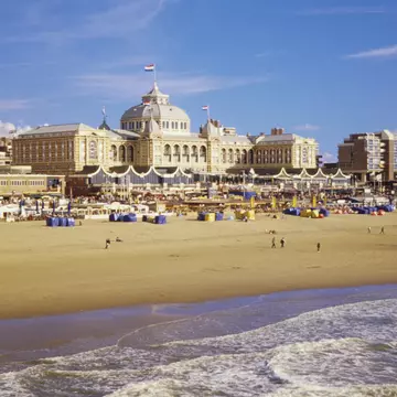 Beachgoers in front of the iconic Kurhaus on the sands of Scheveningen