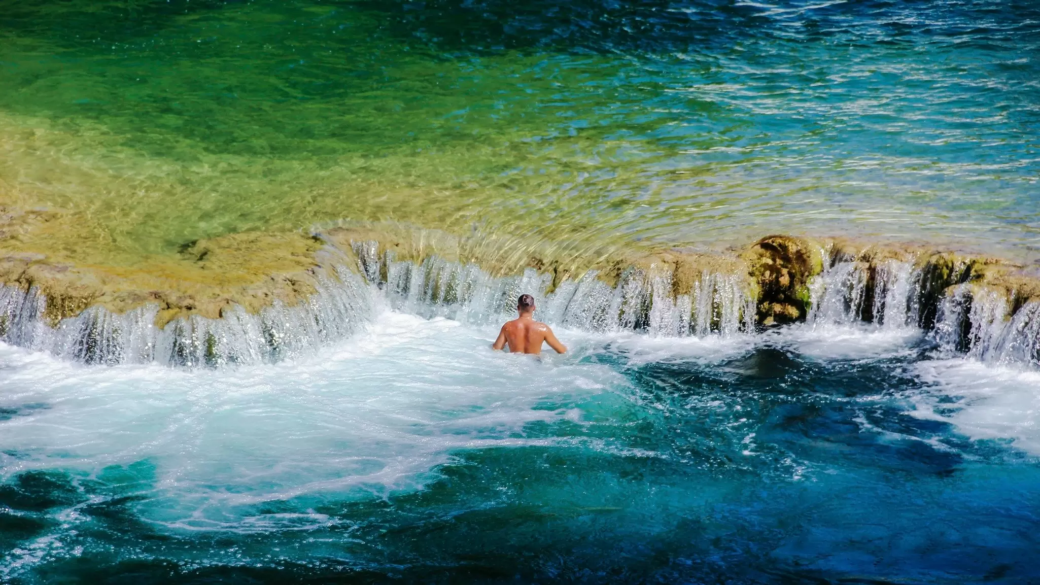 A man swims by the waterfalls at Krka National Park, Croatia. Anita Lucic/EyeEm/Getty Images