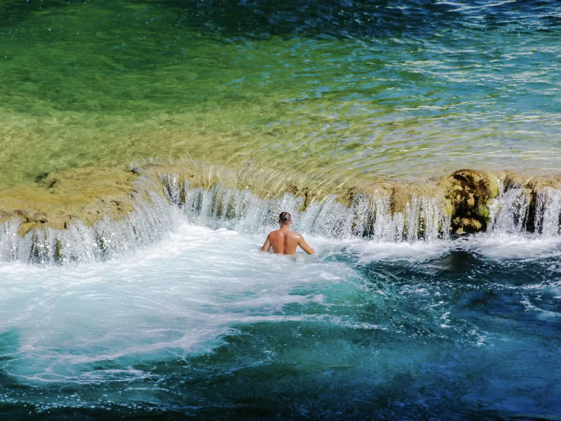 A man swims by the waterfalls at Krka National Park, Croatia. Anita Lucic/EyeEm/Getty Images