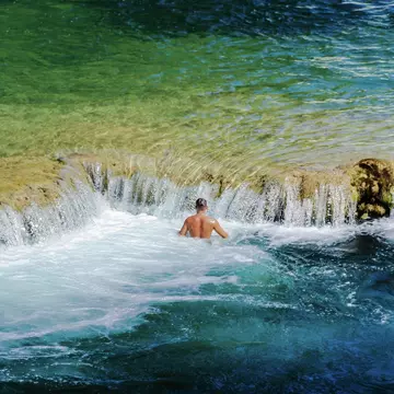 A man swims by the waterfalls at Krka National Park, Croatia. Anita Lucic/EyeEm/Getty Images