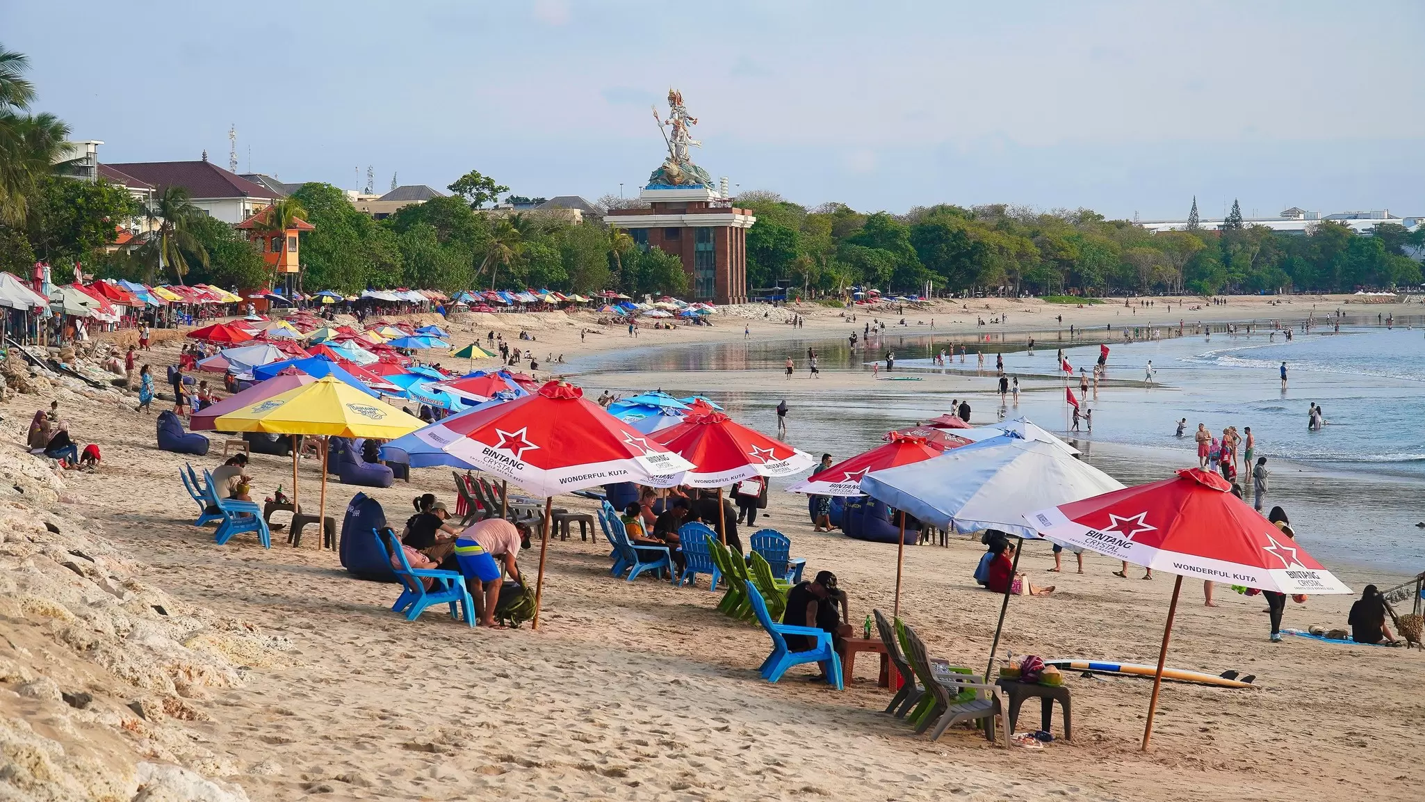 Lines of colorful beach umbrellas on the sand at Kuta in Bali, Indonesia. 