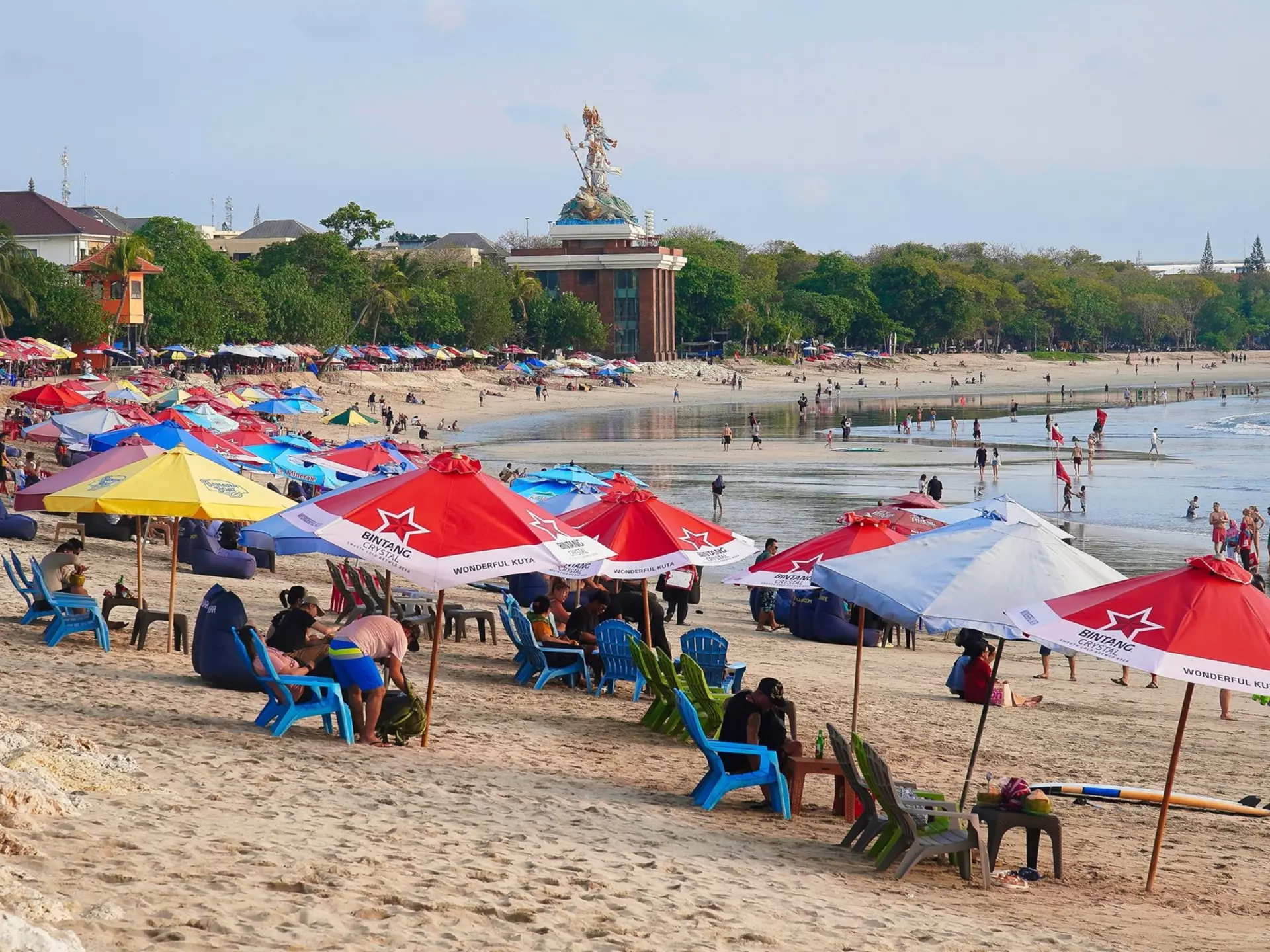 Lines of colorful beach umbrellas on the sand at Kuta in Bali, Indonesia. 