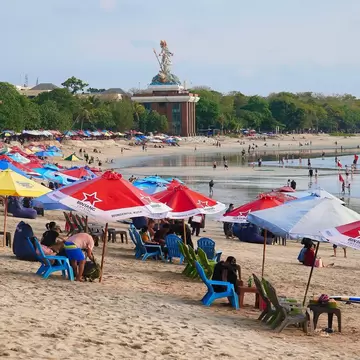 Lines of colorful beach umbrellas on the sand at Kuta in Bali, Indonesia. 