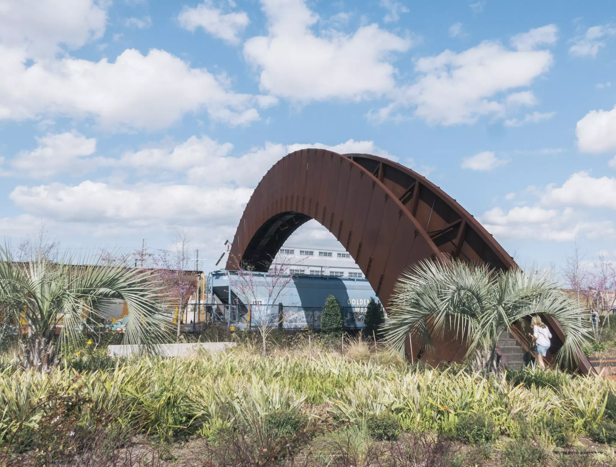 A steel pedestrian bridge spans over train tracks in Crescent Park.