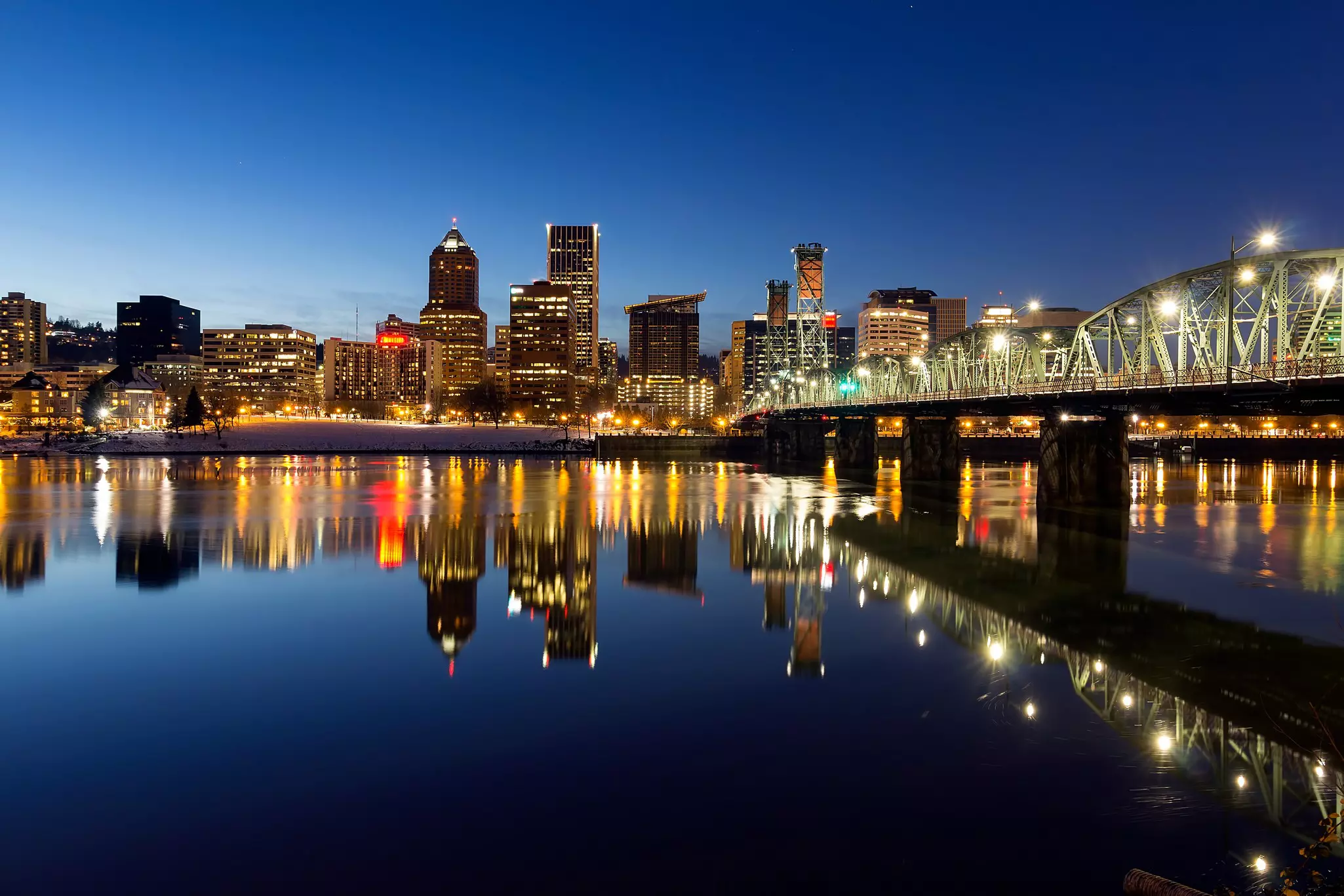 Portland, Oregon downtown skyline along Willamette River during blue hour winter night scene.