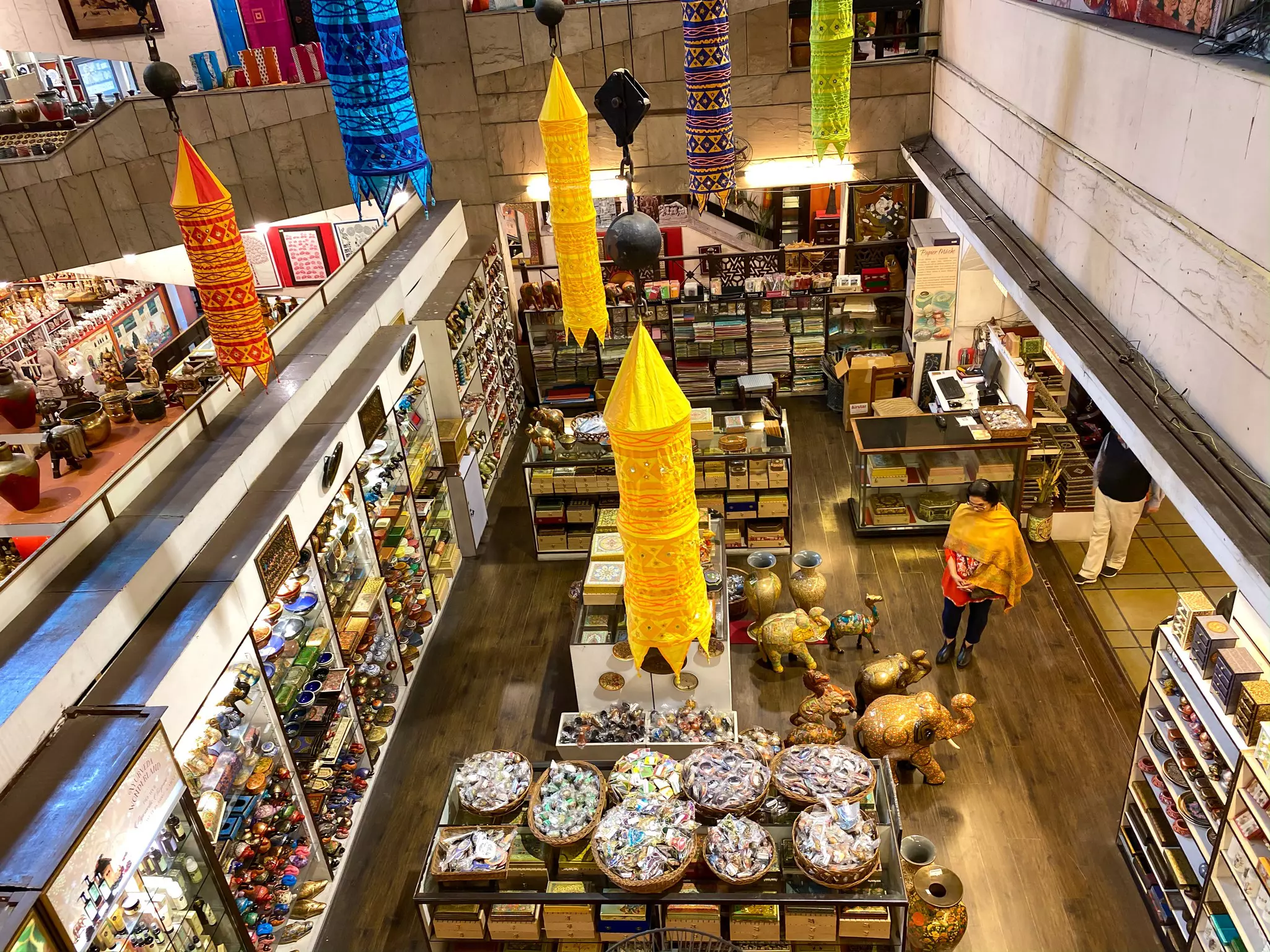A craft shop with displays of goods for sale including small trinkets and larger vases and elephant-shaped ornaments.