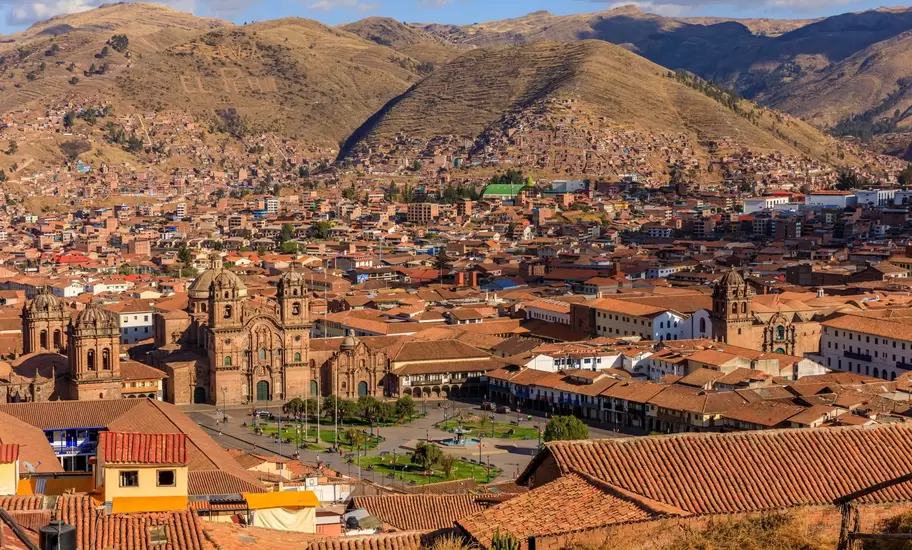Cusco's Plaza de Armas with the Cathedral and Iglesia de la Compañía, red-tile rooftops and brown hills behind