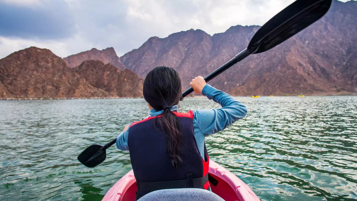 A rear shot of a woman kayaking in a lake