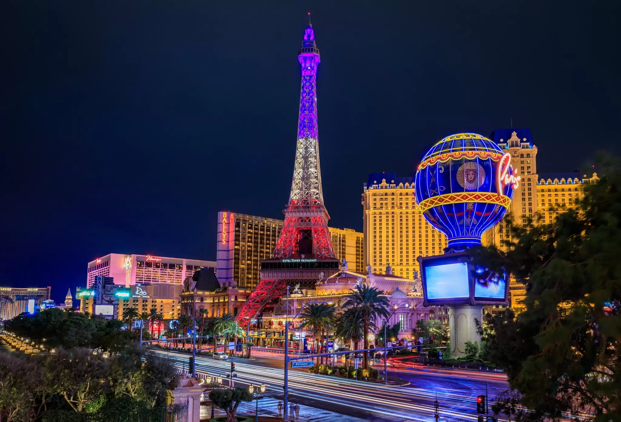  The Strip at night, Eiffel Tower replica, hot air balloon at Paris and other illuminated hotels and casinos.