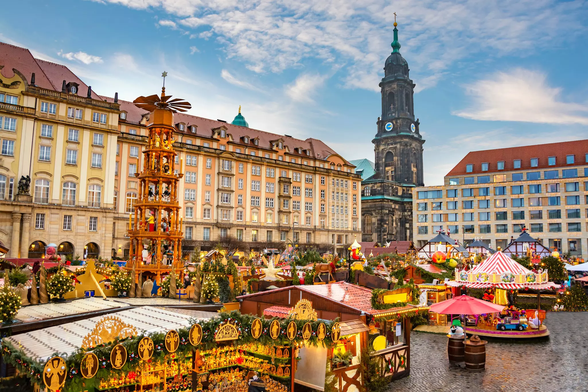 A large city square full of wooden chalets selling Christmas items