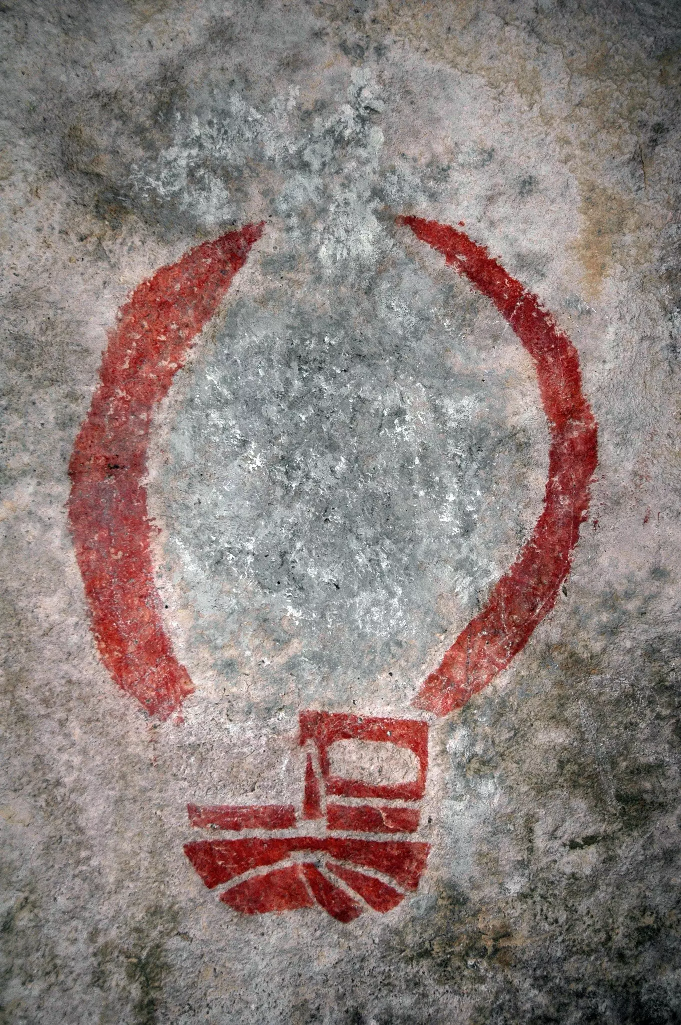 Red rock art on the walls of a cave in Hueco Tanks State Park in Texas.