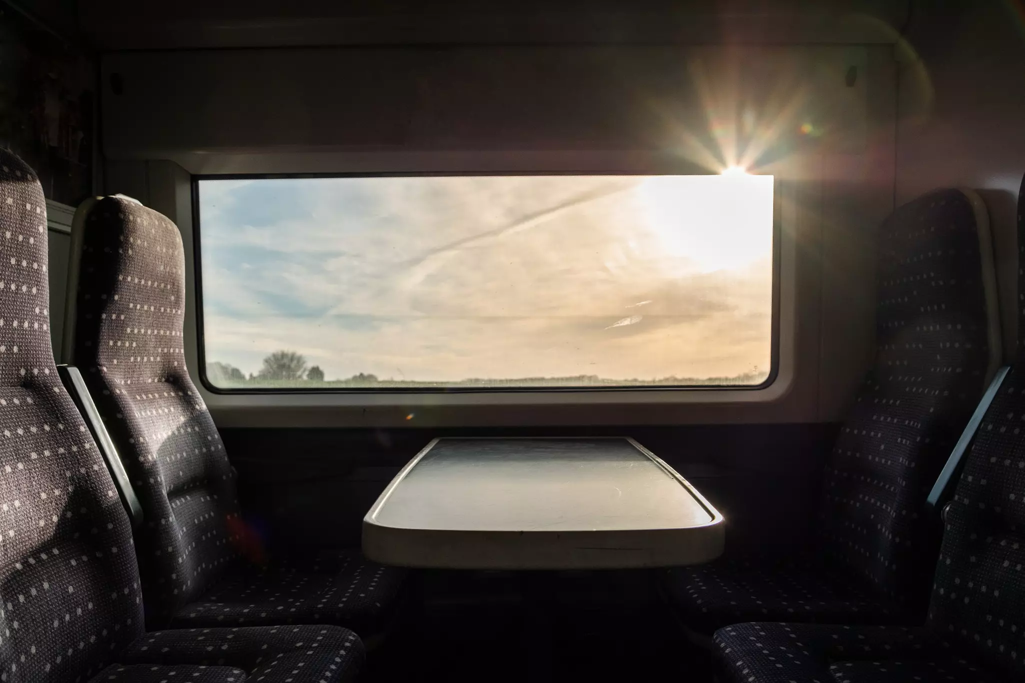 View from inside a english high speed train, travel to destination with noone on board. Trains empty during uk pandemic lockdown. View of the harsh morning sun outside the window