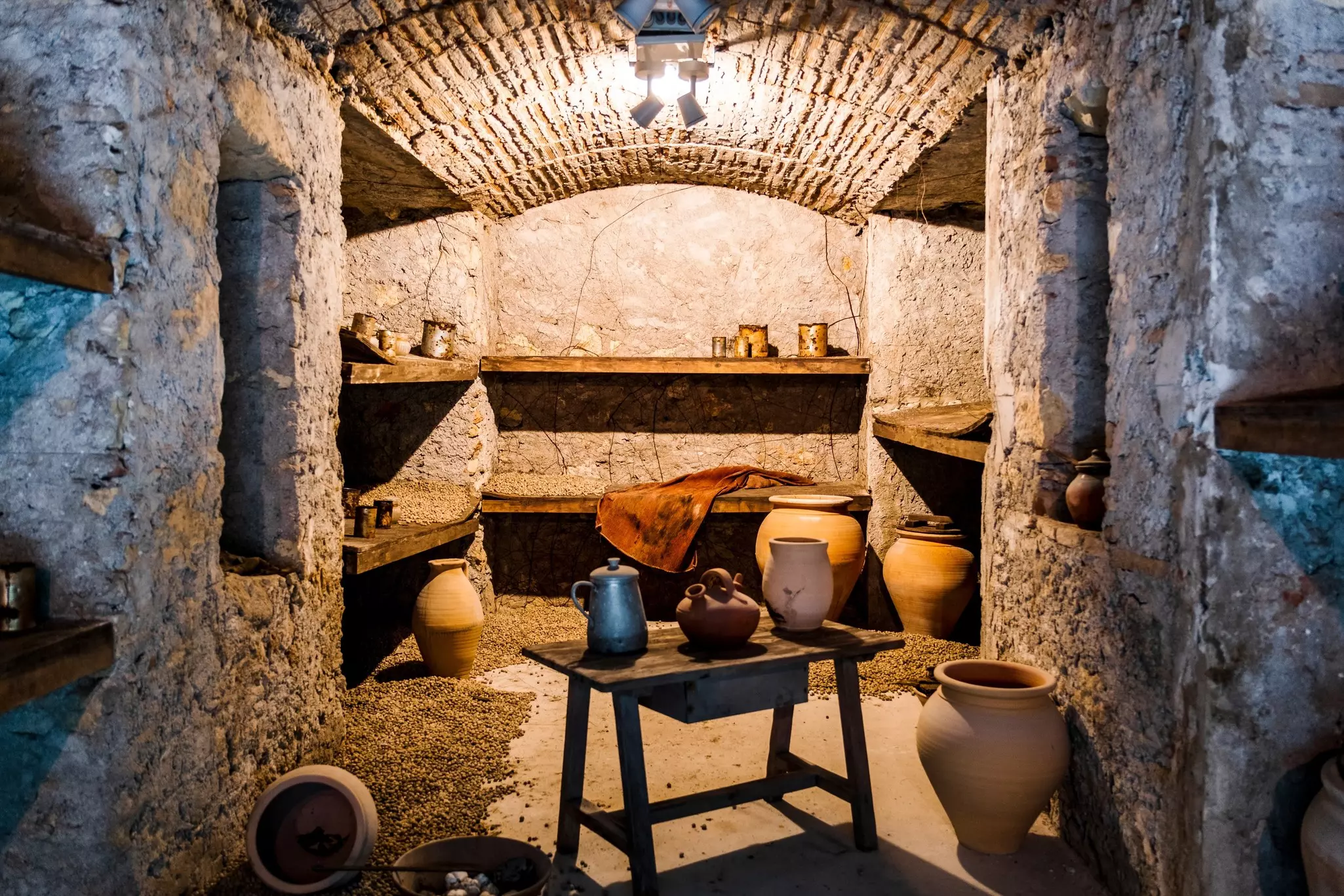 A room in a former underground bomb shelter with pots and vases on shelves  