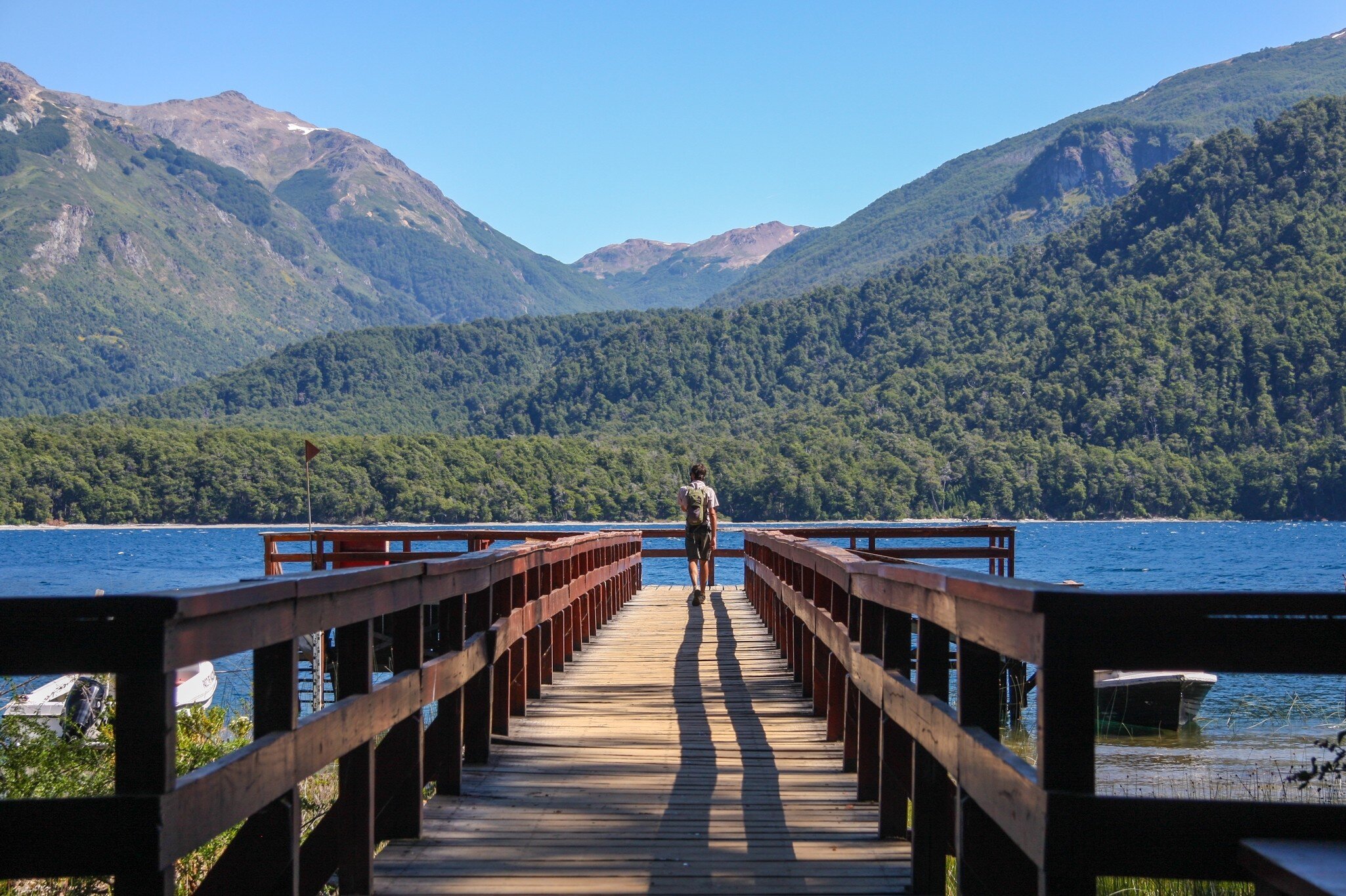 A young traveler walks along the pier at Puerto Chucao on Lake Menendez, Los Alerces National Park, Chubut, Argentina.