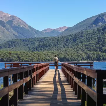 A young traveler walks along the pier at Puerto Chucao on Lake Menendez, Los Alerces National Park, Chubut, Argentina.
