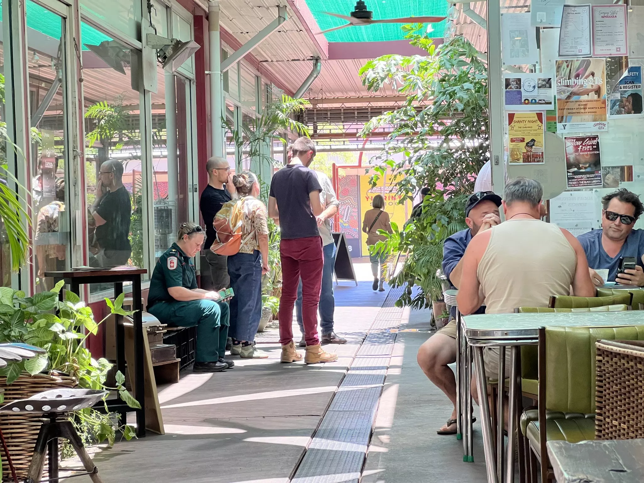 People sit outside a cafe in an alleyway