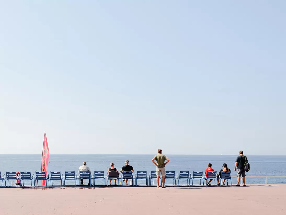People relaxing on the Promenade des Anglais in Nice, France, horizon in the back.