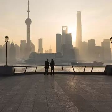 Tourists standing in the Bund, the most scenic spot in Shanghai, China, with skyscrapers in the background.