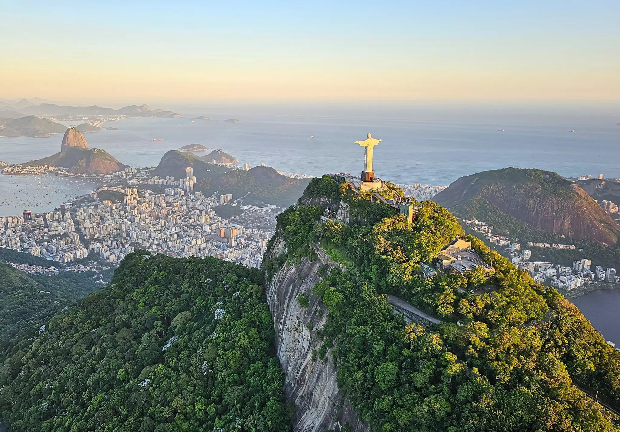 A view of the Rio de Janeiro skyline from above, looking toward the statue of Christ the Redeemer.