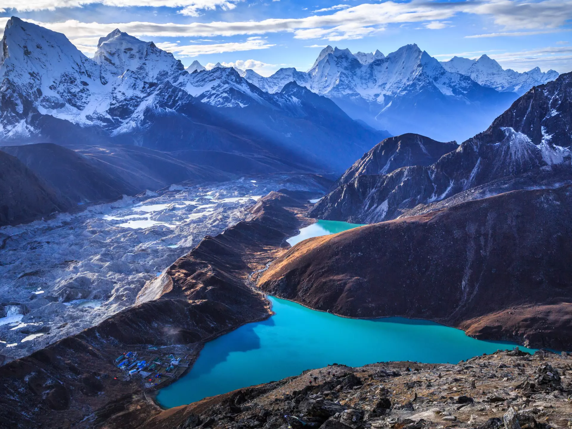 Stunning view of the Himalaya mountains (Cholatse and Taboche to the left), Ngozumpa glacier, and Gokyo lakes (the world's highest freshwater lakes, sacred for both Hindus and Buddhists), as seen on top of Gokyo Ri (5,357 m), near the village of Gokyo, in Sagarmatha National Park, UNESCO World Heritage Site in Khumbu region, Solukhumbu district, eastern Nepal, Asia.
Asia; Beauty In Nature; Blue; Cloud - Sky; Cold Temperature; Color Image; Day; Dusk; Gokyo; Gokyo Lake; Gokyo Peak; High Angle View; Himalayas; Horizontal; Khumbu; Lake; Landscape; Majestic; Mountain; Mountain Range; Nature; Nepal; No People; Outdoors; Photography; Reflection; Sagarmāthā National Park; Scenics; Sky; Snow; Snowcapped Mountain; Solu Khumbu; Standing; Sunlight; Tranquility; Travel Destinations; Turquoise Colored; UNESCO World Heritage Site; Village; Winter;