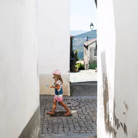A child walks between cobblestone alleys