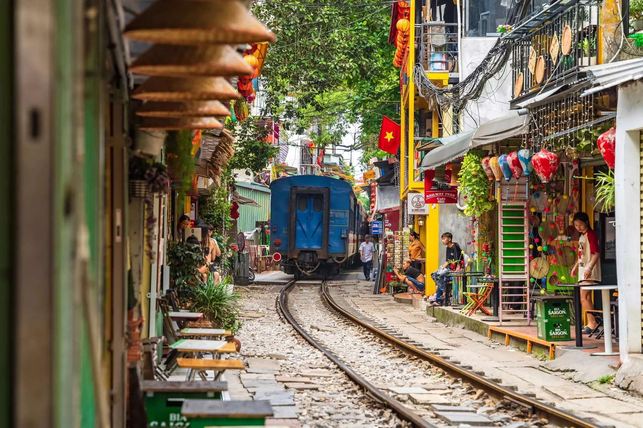 A train passes through a narrow street in Hanoi's Old Quarter.
