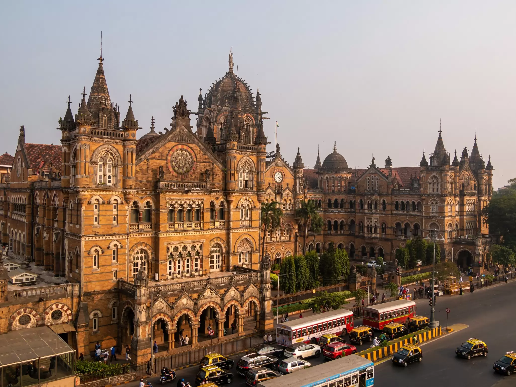 A large golden stone building with many turrets and domes, as well as an elaborately carved exterior.