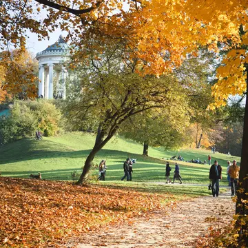 People walking and enjoying the autumn sun in English Garden.