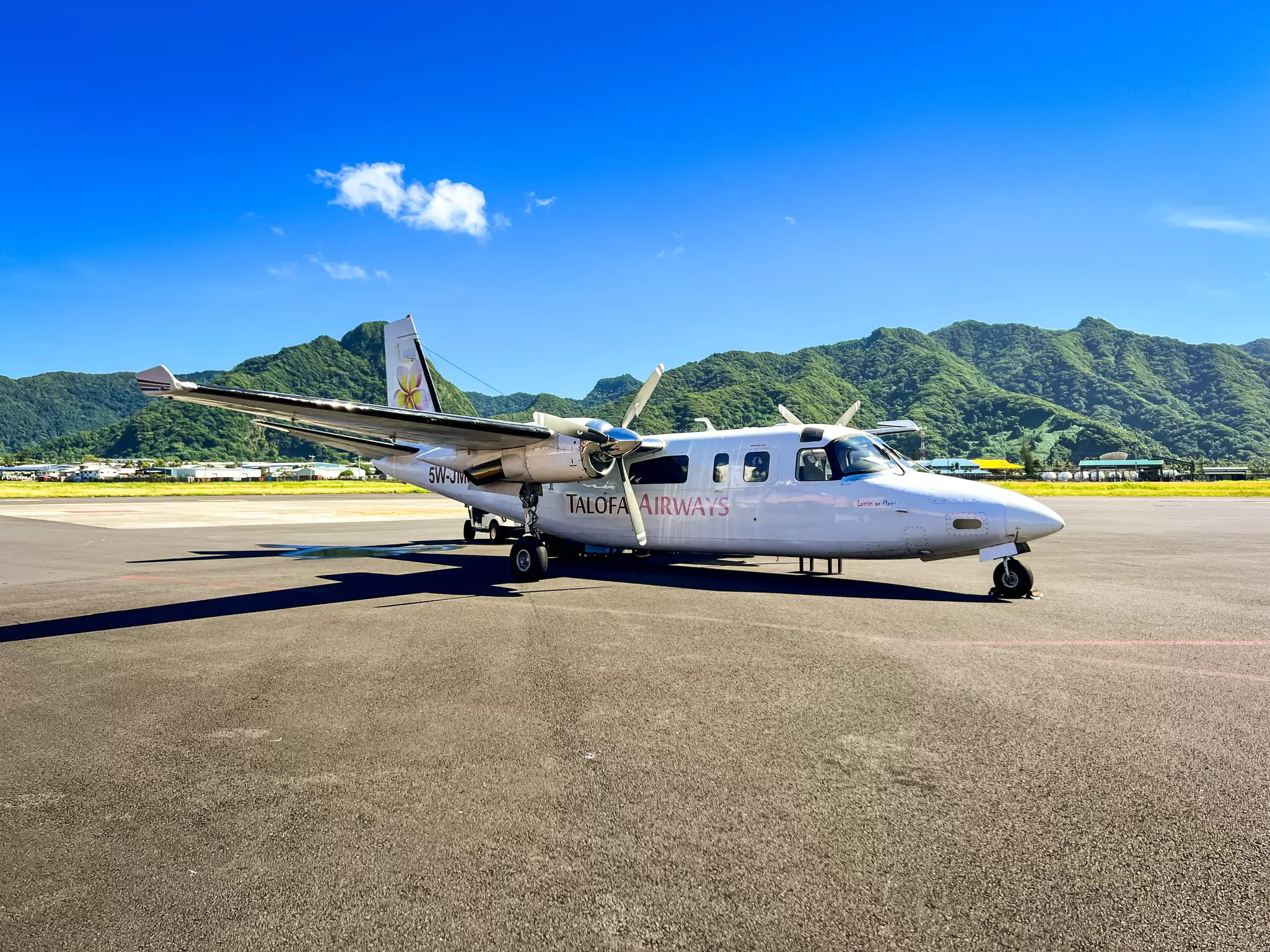 A small propellor aircraft with mountains in the background