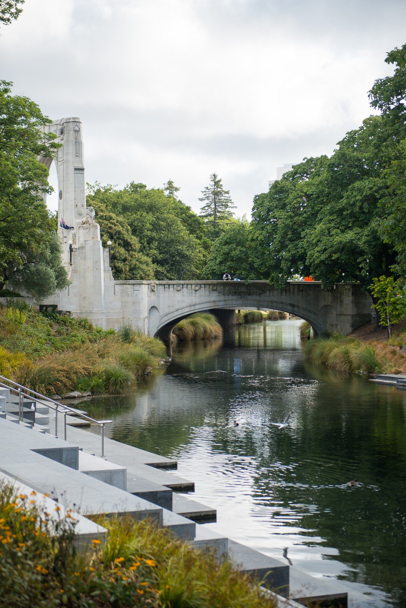 A group of people standing on a bridge above the Avon River in North Hagley Park, Christchurch.