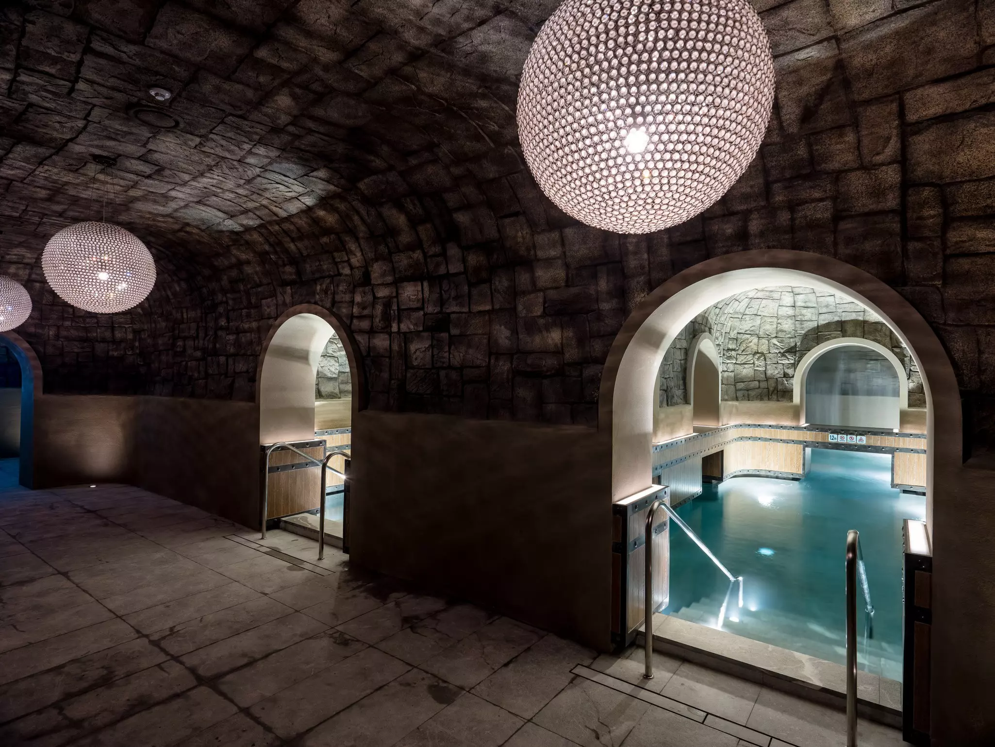 The Cave at Cimer Spa in Incheon, South Korea, featuring a pool with soft lighting and arched entrances.