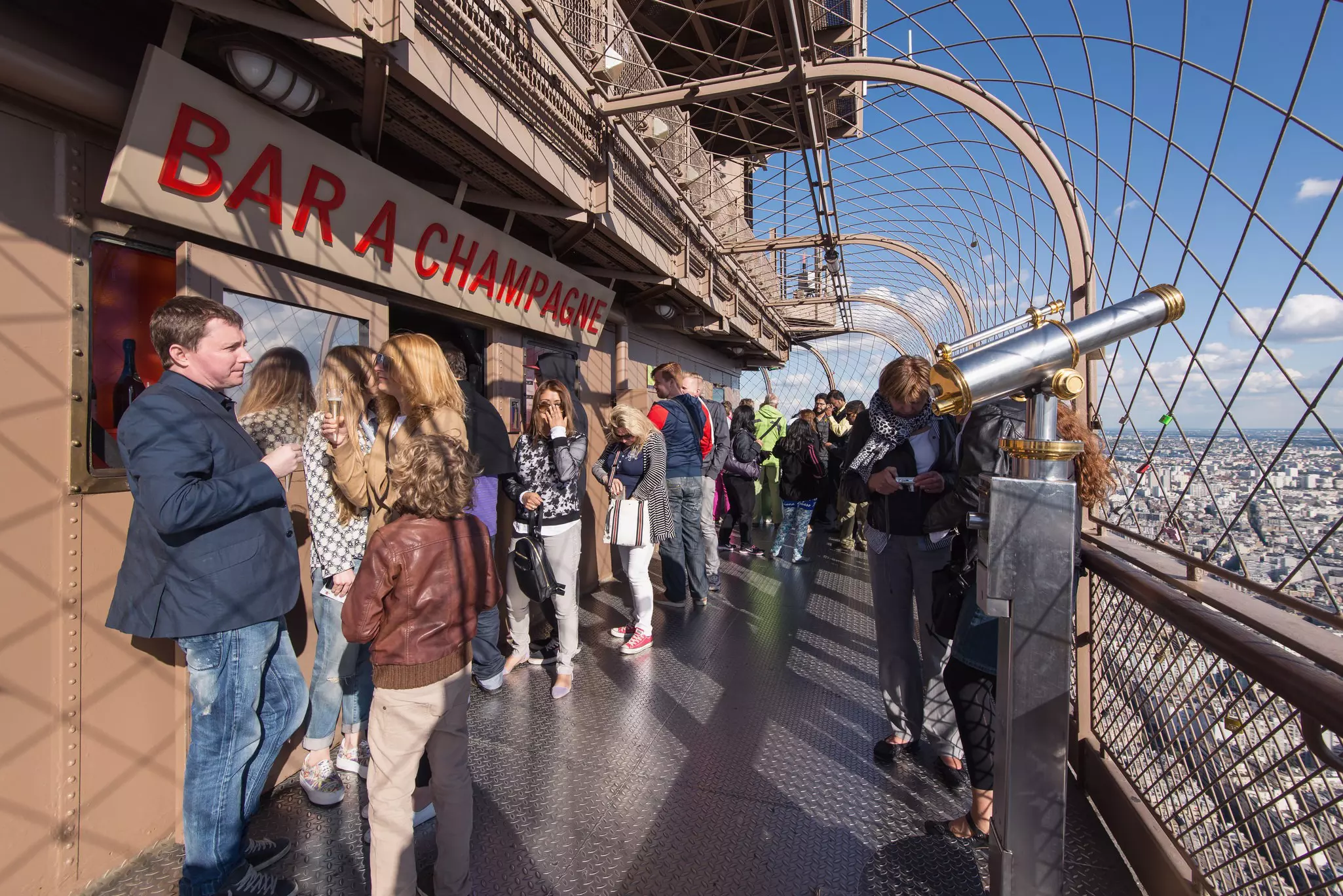 Tourists at the top of Eiffel Tower at Bar Champagne.