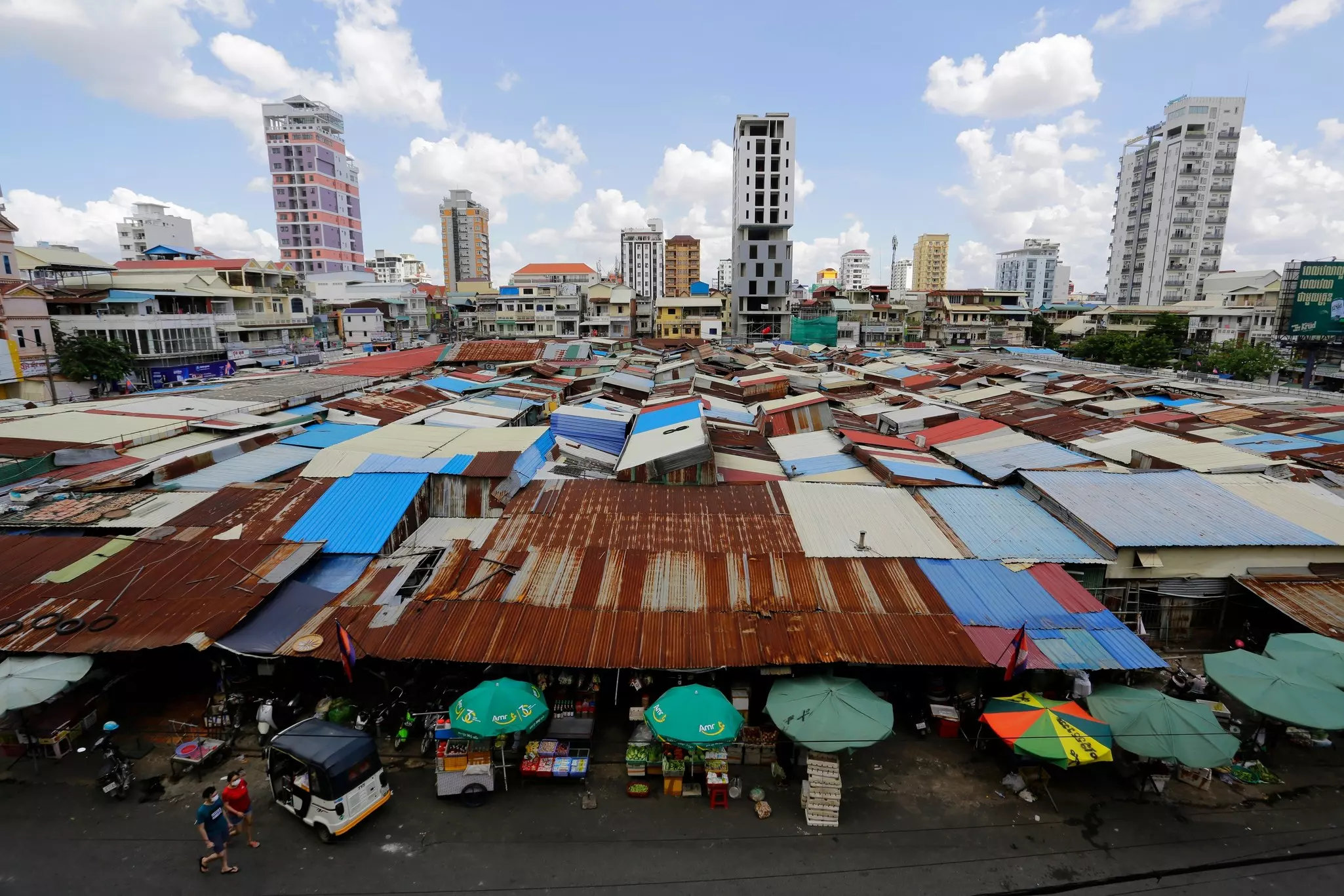 An aerial view of the patchwork roofs of a market in Cambodia.