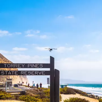 San Diego, California - October 08 2017: Entrance sign to Torrey Pines State Reserve park and beach in La Jolla on hot sunny summer day. Sandstone cliffs and people walking towards the ocean behind.
1195344913
america, american, coast, coastal, destination, dunes, heat, hot, landscape, ocean, outdoor, pacific, path, pine, scenery, scenic, southern, sunshine, torrey pines, tourists, trail, trees, turquoise, united states, vacation, view, west