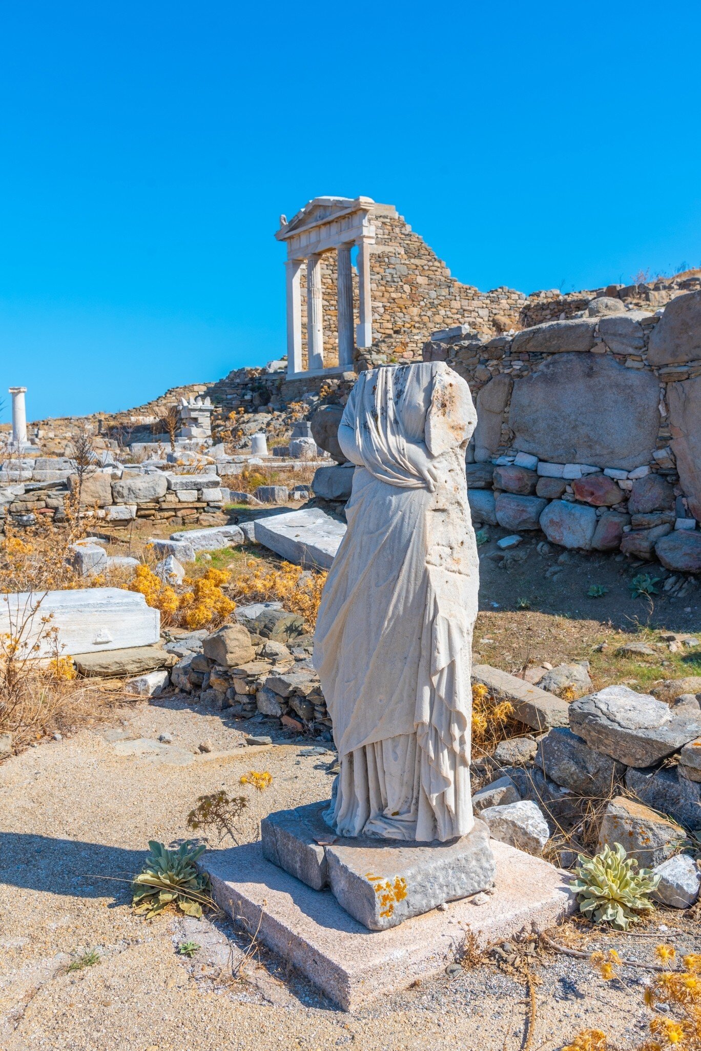 View of ancient ruins and statues on Delos Island near Mykonos, Greece.