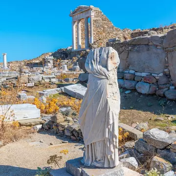 View of ancient ruins and statues on Delos Island near Mykonos, Greece.